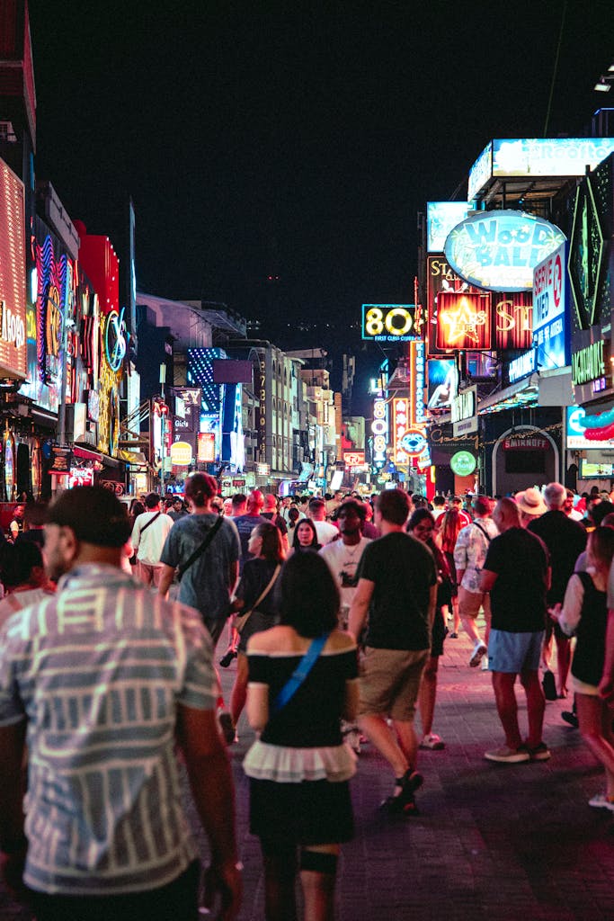HOME Bustling street with neon lights and crowds enjoying Bangkok's lively nightlife.