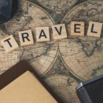 Vintage map with travel essentials like camera and sunglasses arranged in a flat lay, perfect for adventure themes.