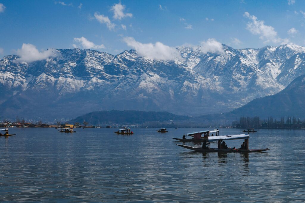 HOME Boats floating on Dal Lake with the snowcapped Himalayas in the background in Srinagar, India.