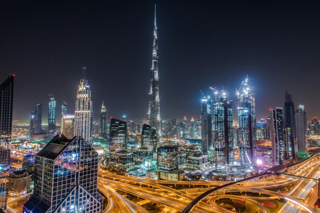 HOME A stunning view of Dubai's illuminated skyline featuring the towering Burj Khalifa at night.